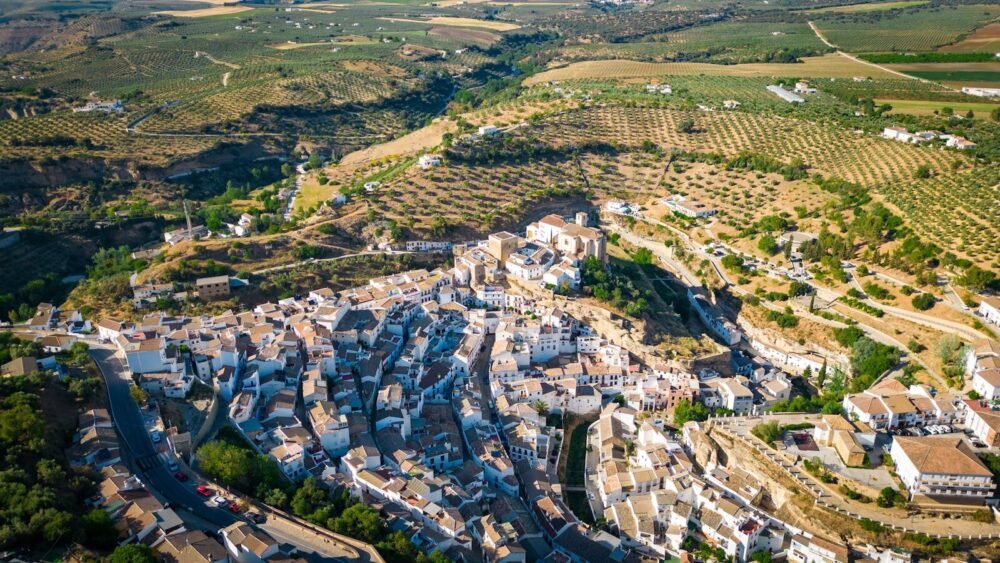 A stunning aerial shot of Setenil de las Bodegas, showcasing its unique cliffside houses and lush surroundings.